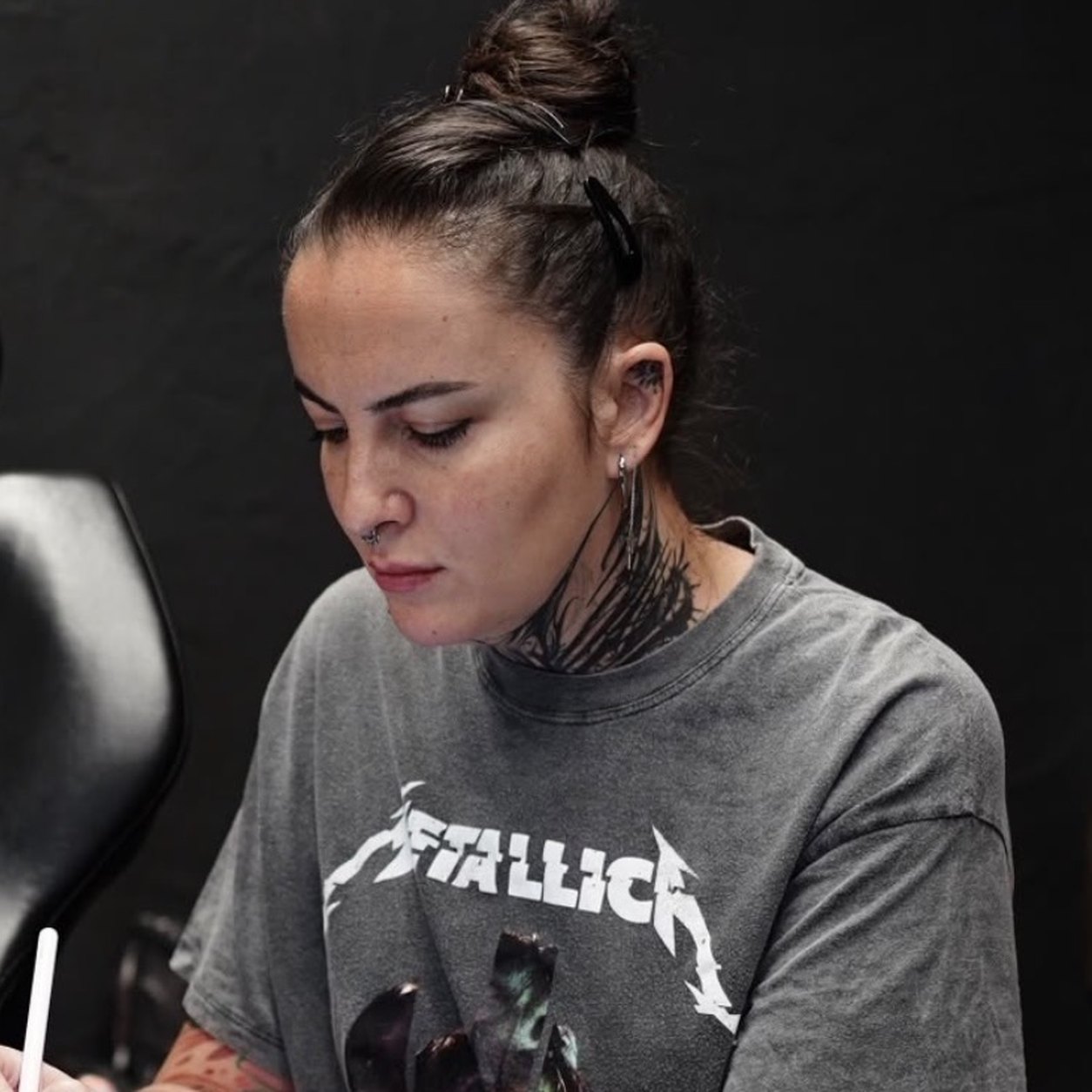 Tuba, botanical blackwork and fine dotwork tattoo artist at THRONE Northampton, drawing a design on an iPad in the studio