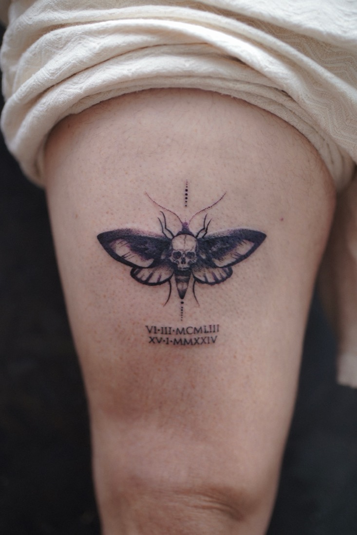 Death’s-head hawkmoth with roman numerals below it, on a thigh, by Tuba at THRONE Northampton