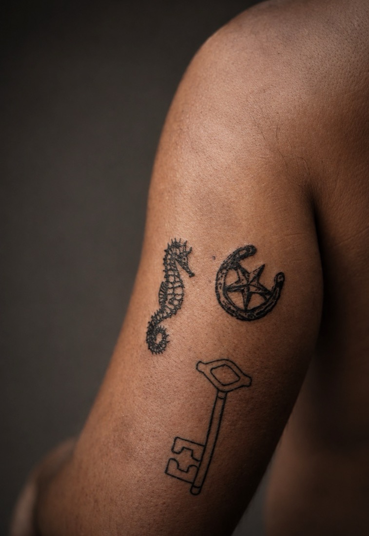 Seahorse, horseshoe with a star, and a key on an upper arm, by Tuba at THRONE Northampton